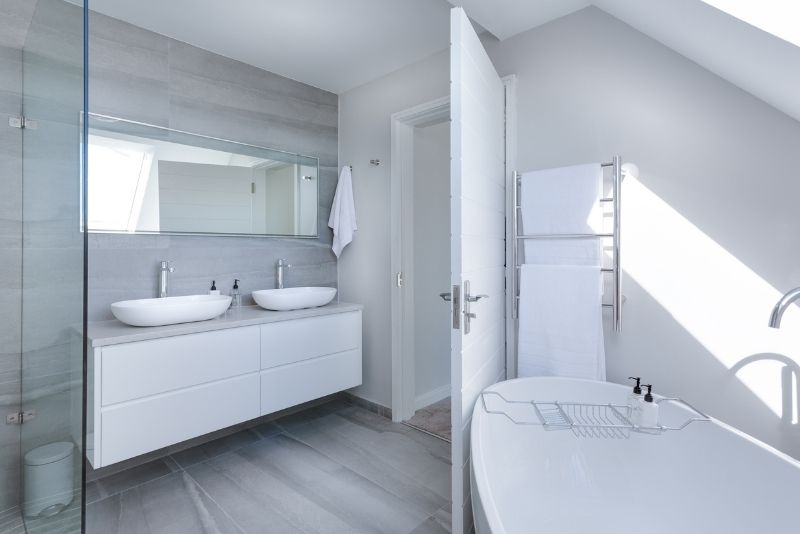 white themed bathroom design with towel bath tub and vanity table